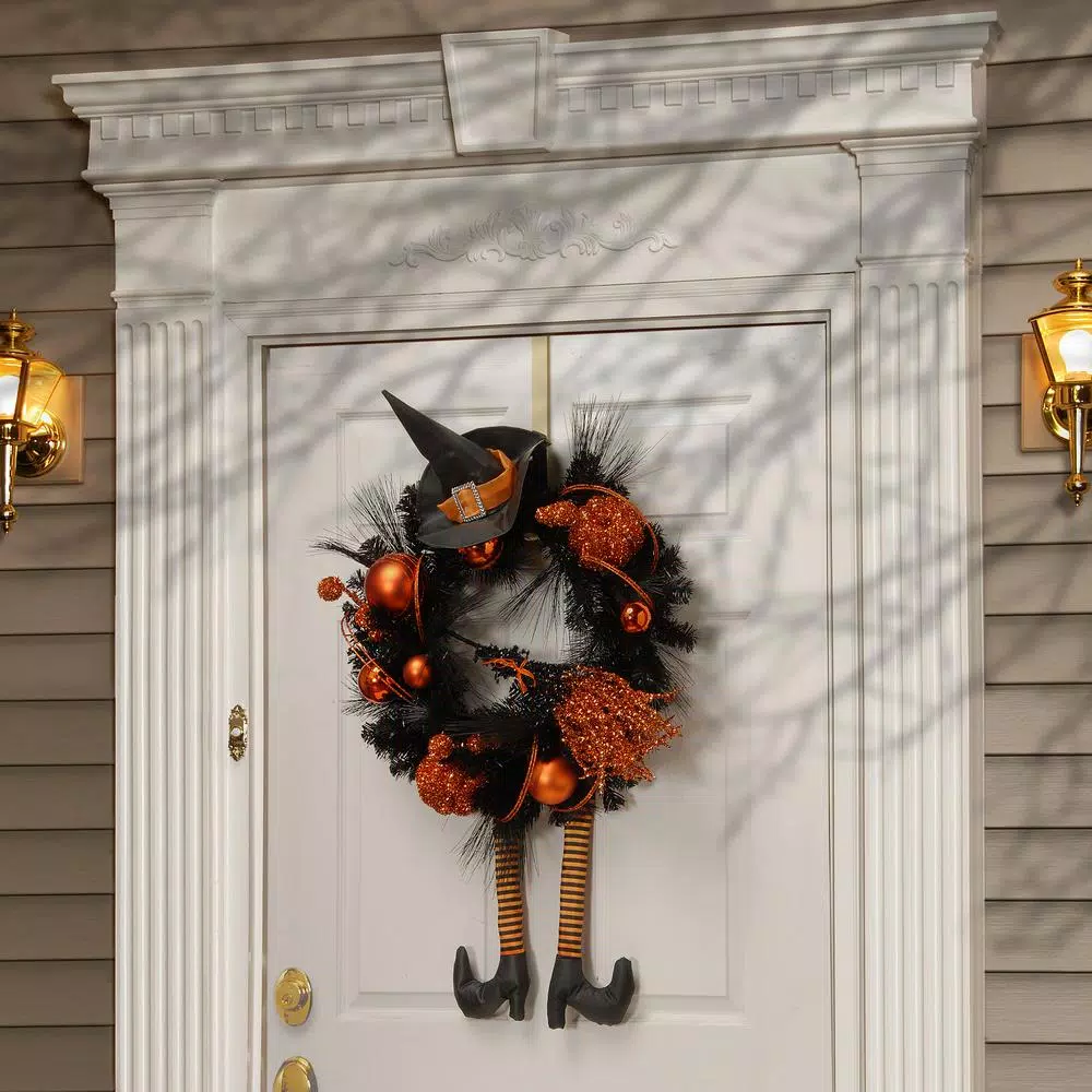 National Tree Company 24 in. Halloween Witch Wreath with Witch Hat, Striped Legs, and Glittered Broom