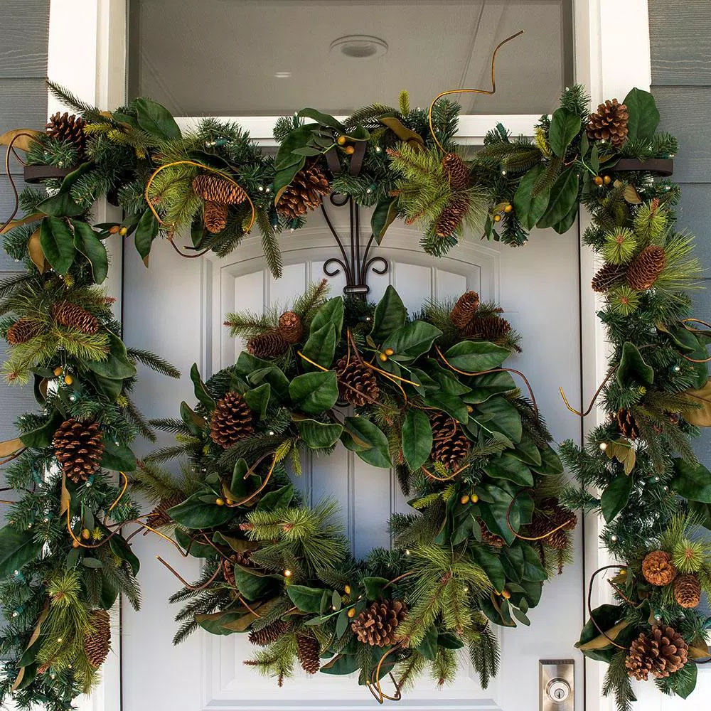 Village Lighting Company 9 ft. Pre-Lit LED Magnolia Leaf Garland with Pinecones and Warm White Lights