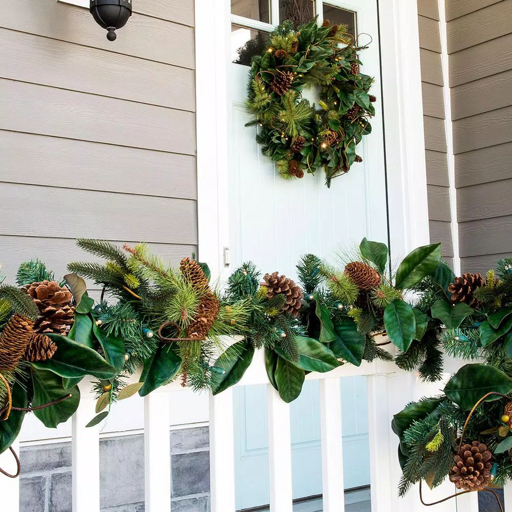 Village Lighting Company 9 ft. Pre-Lit LED Magnolia Leaf Garland with Pinecones and Warm White Lights