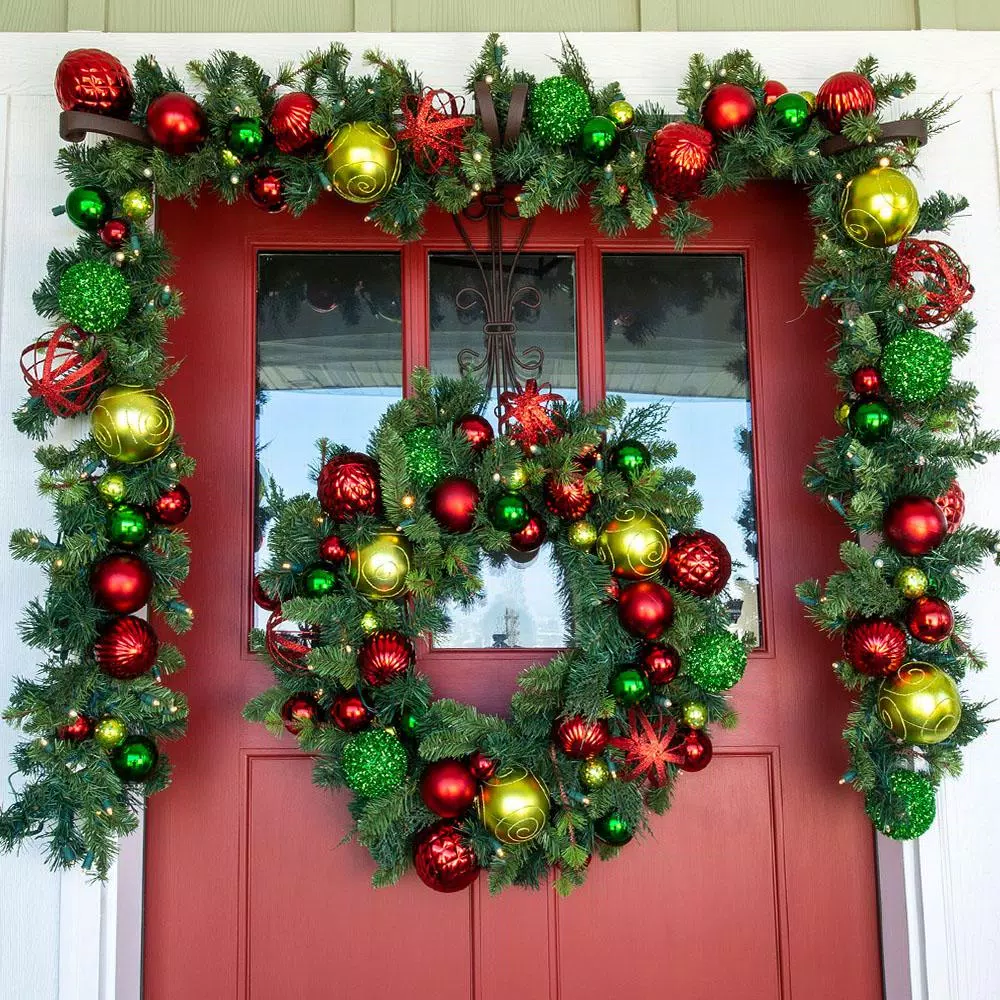 Village Lighting Company 9 ft. Pre-Lit LED Festive Holiday Pine Garland with Red and Green Ornaments