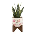 Flora Bunda 12 in. Faux Snake Plant in Floral White Ceramic Pot with Wood Stand thumbnail 1